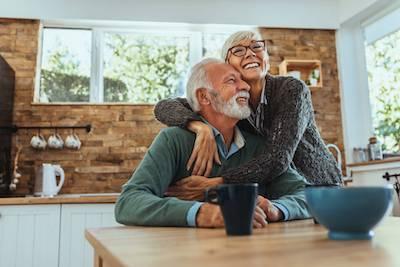 couple laughing in kitchen | Dental Crowns Charlestown