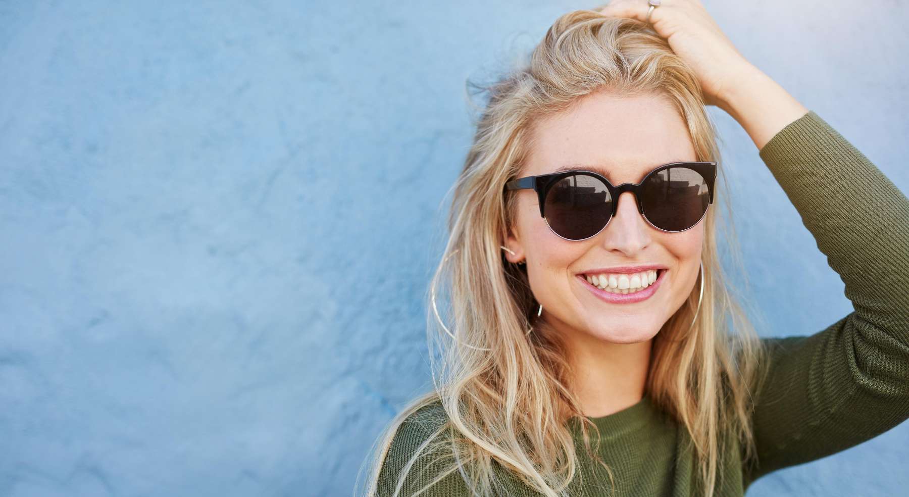 A smiling woman in sunglasses | cosmetic dentist in Charlestown NSW