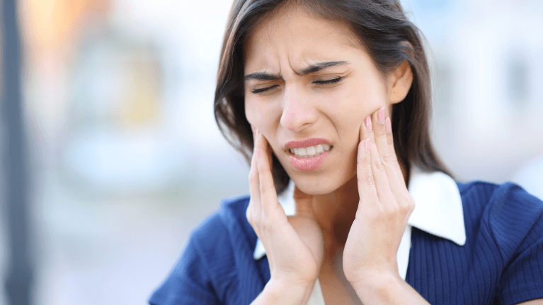 woman holding her jaw in pain in Charlestown, NSW