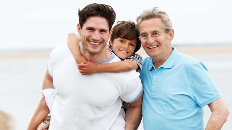 A smiling family on the beach | dentist Charlestown NSW