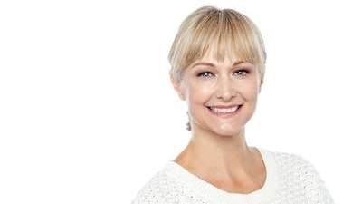 A woman in white smiling | dental veneers in Charlestown NSW