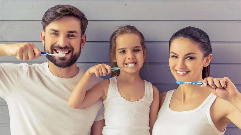Family brushing their teeth together
