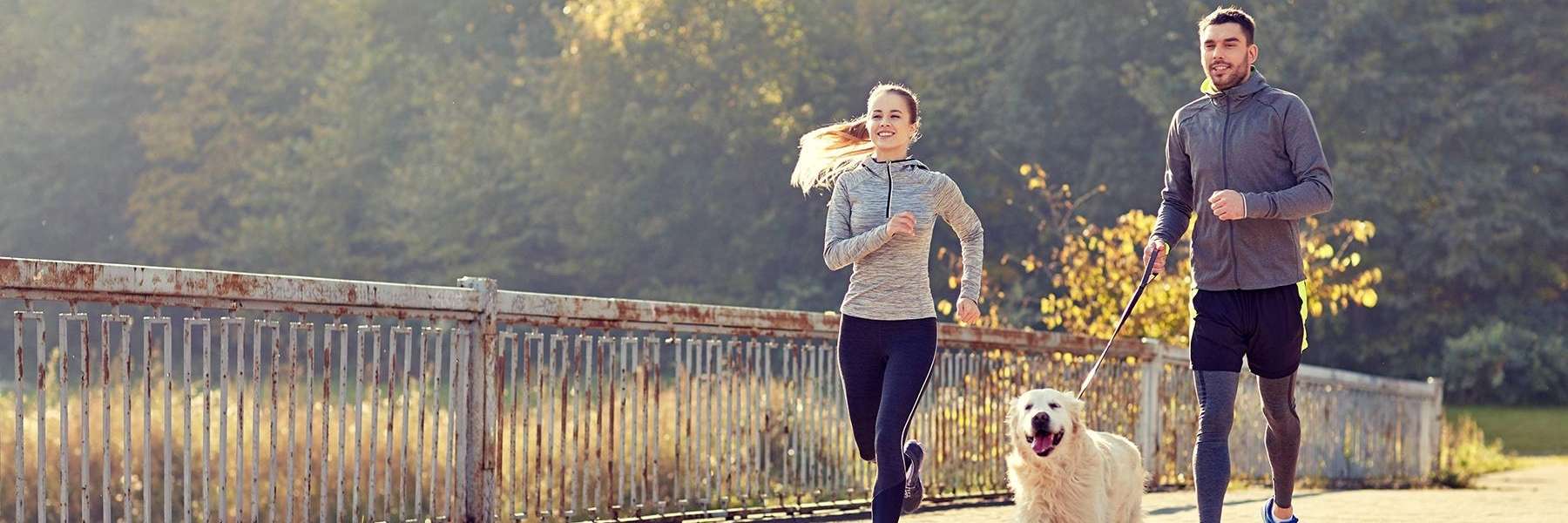 Man and woman running with a dog | Dentist Charlestown